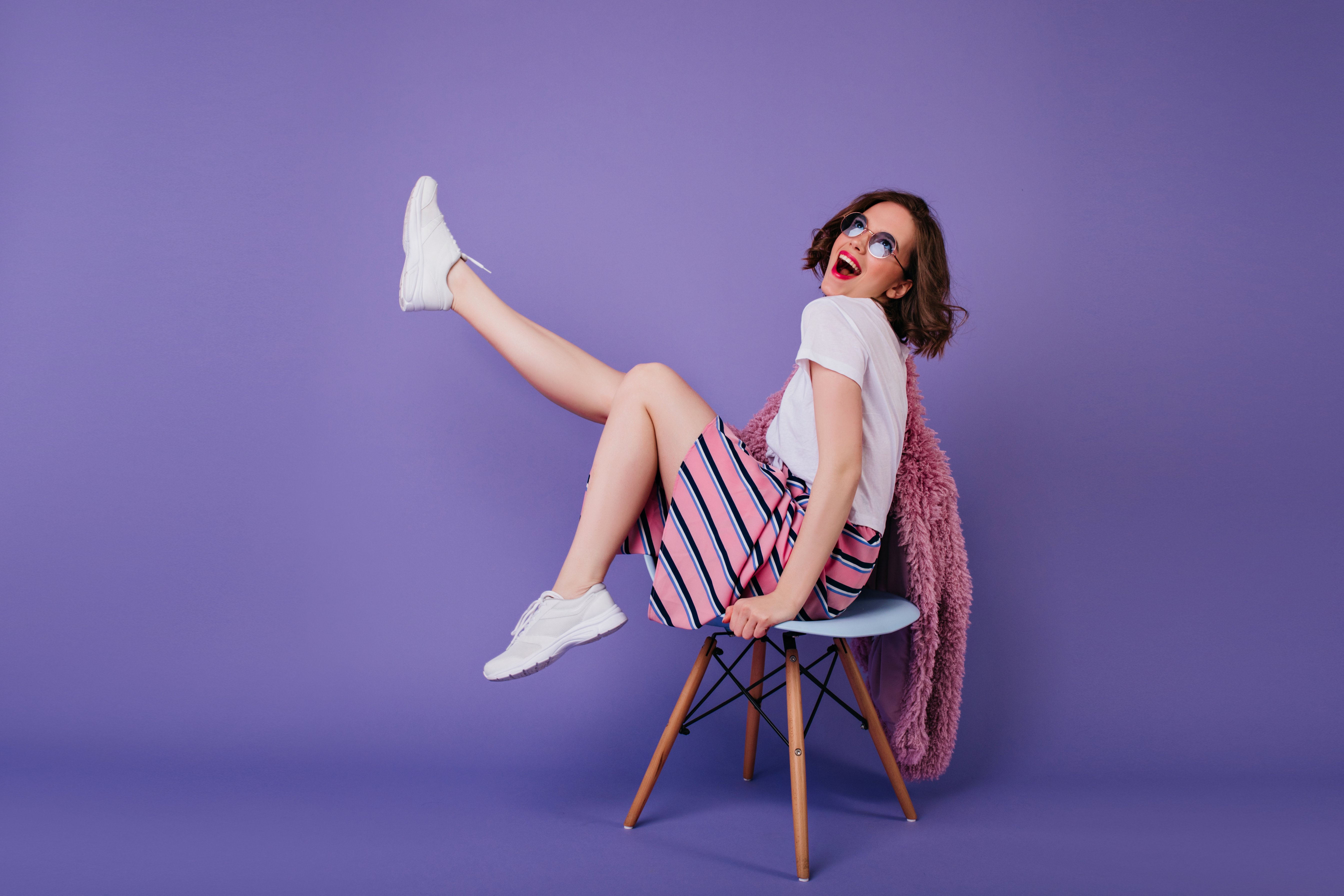 Romantic Girl in White Shoes Sitting on Chair and Laughing in St